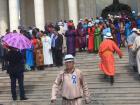 Some people in traditional dress on the steps of Parliament. 