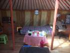 The bed and table inside of a ger. 