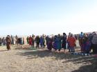 People in warm clothes gathering to watch horses. 