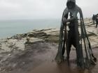 A statue of King Arthur at the top of the Tintagel Castle ruins