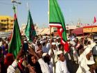 People marching streets during Mawlid carrying different flags representing different Islamic groups