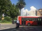 A common city bus and motorcycle on the street