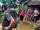 A Hmong family observes Josh, while he stops for a short rest in their village.