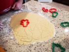 Josh is "stamping" his cookie dough into Christmas-themed shapes. 