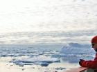 Expedition leader John Shears on the deck of the ship, overlooking icy waters