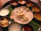 A vegetarian thali, a type of meal that is served in a round platter with many small bowls