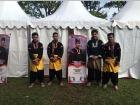 Wearing traditional Silek clothing, which includes a colorful sarong tied around black clothing