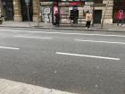 A group of people waiting at a typical bus stop