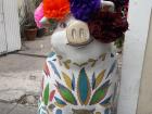 A pig statue wearing traditional hair flowers from Dia de Muertos, or Day of the Dead