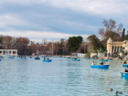 Retiro park on a nicer day with people rowing around.