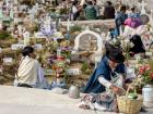 People celebrating Dia de los Difuntos in a cemetery 