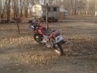 A motorbike outside of a Shed