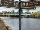 A sign along the river path pointing out places within walking distance