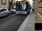 A city bus drives down a narrow street in Florence
