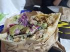 A (half-eaten) shawarma with different vegetables