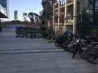 A crowded drop-off area for the scooters and bikes to rent that people use to commute