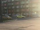 Two yellow taxis and a surprisingly colorful communist style apartment building