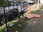 A trash basket near an apartment building