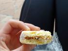 An alfajor, dulce de leche sandwiched between two shortbread cookies and rolled in coconut on the sides