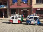 Some tiny and colorful taxis in a small town