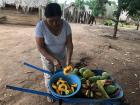 My host mom cutting a papaya for the family pig