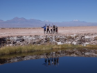My friends and me at Ojos de Salar—you can see our reflections in the water!
