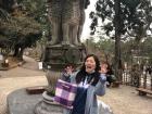 Misato is posing in front of a statue at a temple nearby