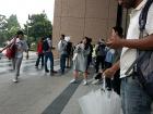 This line of foreigners spilling outside of the building lobby is waiting to take a Japanese language proficiency test