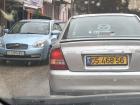 On the left, you see a Palestinian green and white license plate and on the right, a yellow Israeli plate