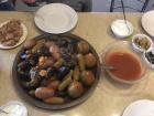 A whole tray of delicately stuffed zucchini (kousa mahshi), eggplants and potatoes served with tomato sauce and yogurt on the side