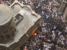 The first runner holding the Holy Flame coming out of the Tomb of Jesus in Jerusalem ready to spread the flame around the world