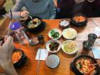 Soft tofu stew is served with small side dishes and rice