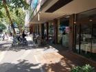 The sidewalk alongside the school has plenty of cafes to choose from