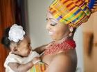 A mother wearing traditional kente fabric to celebrate her baby's naming ceremony (https://encrypted-tbn0.gstatic.com/images?q=tbn:ANd9GcRTMD_KsBFhRwnW5ODN4IqwYyW4YhMFaBGPWfgNKLXGcfalpg6S1Q)