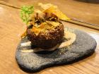This pincho is called patacon.con and is made of fried plantain, pork rind, black onion foam, and dehydrated olive