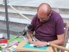 A pigeon watching a man draw