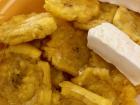 Fried unripe plantains are sprinkled with salt and often served with blocks of cheese