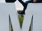 Young adults sitting on the "M" in the Montevideo sign