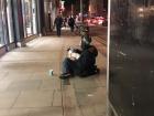 A man sits with his dog outside my local grocery store, asking for spare change