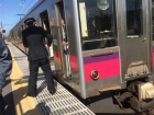 A worker is taking tickets from passengers after they get off the train