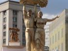 A statue of two peasants holding a bundle of wheat