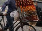 Man selling candy sticks on a bike