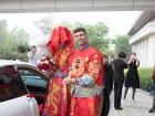 Couple arrives to wedding with bride wearing a veil of satin