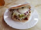 A Döner sitting on a plate with layers of ingredients showing