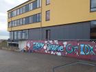 A student-made mural decorating the wall of a schoolyard