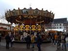 A double-decker carrousel painted with images of the Pfalz, providing rides for small visitors to the Landau Christmas market