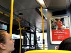 The inside lower level of a double decker bus, with sign in both Gaelic and English