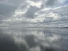 The still water reflects the sky like a mirror