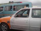 A taxi and trotro driving next to each other on the highway