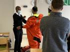 Purser Siyabonga demonstrating the use of a survival suit during safety drills
